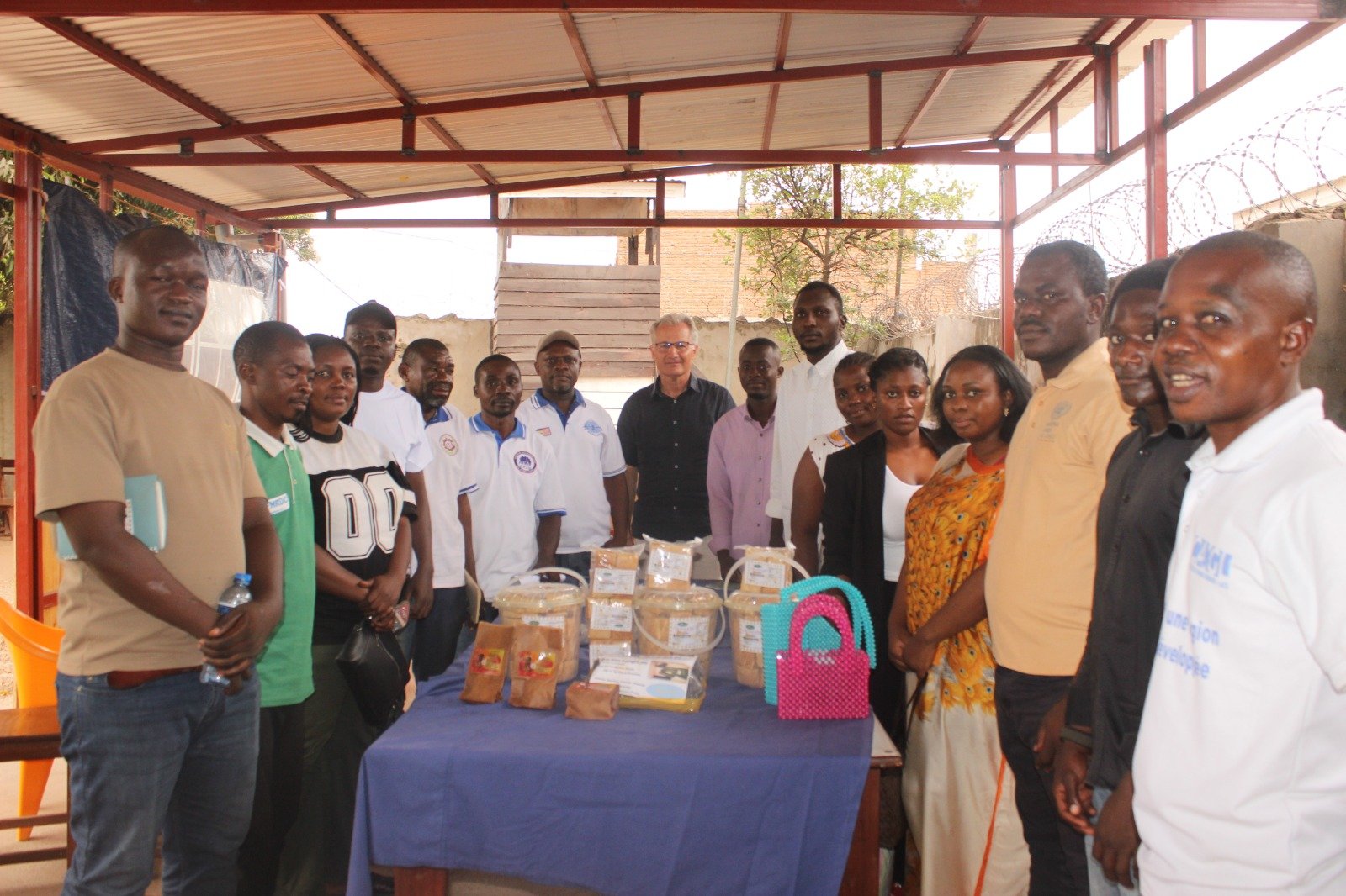 Photo de famille réunissant M. Thierry Le Noir et les membres des organisations locales d'Uvira lors de l'exposition des produits artisanaux et locaux.